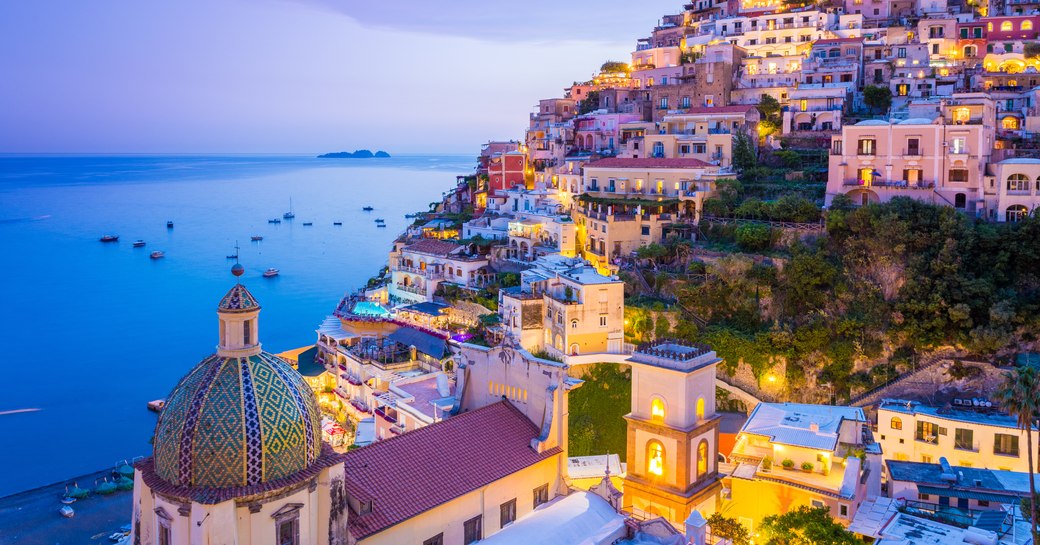 View of the town and the seaside in a summer at sunset